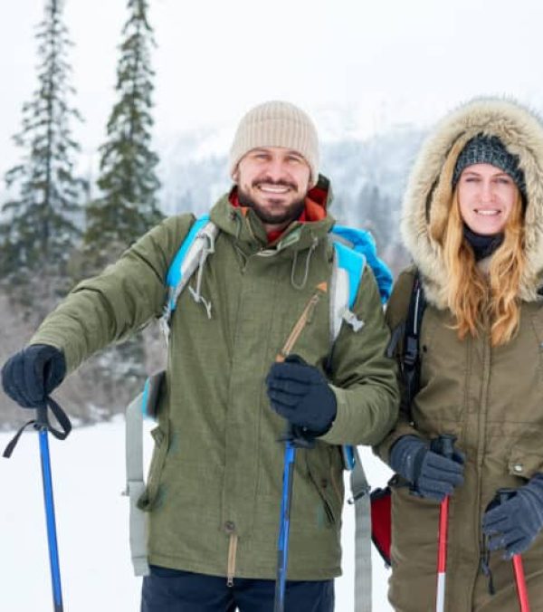couple snowshoeing in a snowy field in the forest - winter getaways - Valentine's Day North Lake Tahoe